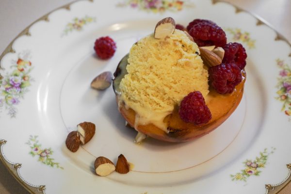 Peach ice cream in a caramelized peach, with raspberries and toasted almonds at The Wallace House. (Crystal Shi/Epoch Times)
