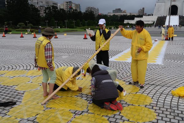 Falun Gong practitioners help out with the character formation preparation in Taipei on Nov. 24, 2016, two days before the actual formation. (Frank Fang/Epoch Times)